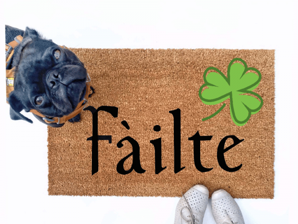 Failte shamrock St Patrick's day coir doormat with a little black pug