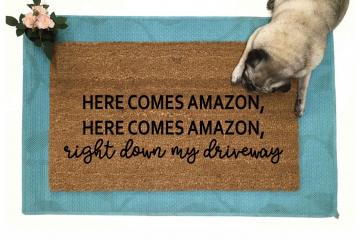 doormat reading "Here comes Amazon, right down my driveway" on blue rug with pug