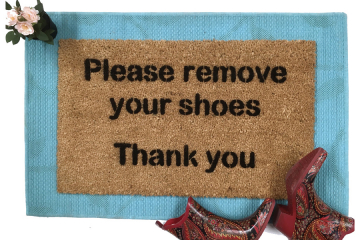 doormat reading Please remove your shoes Thank You on a blue layering rug with p