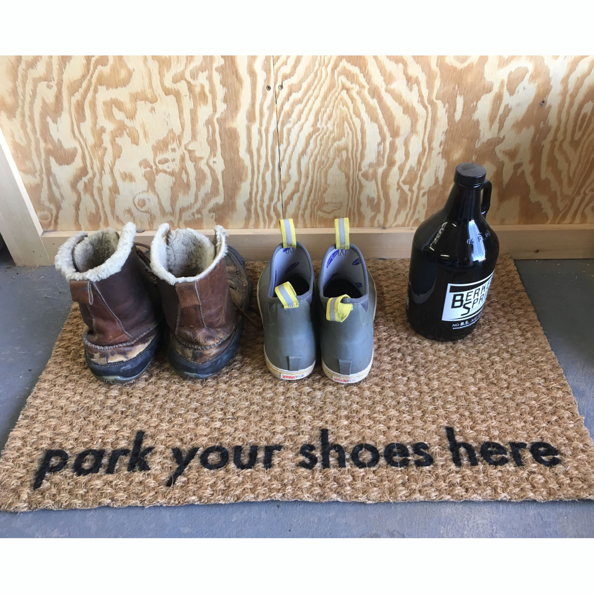 picture of woven coir doormat with words park your shoes here on it and several pairs of boots in a garage