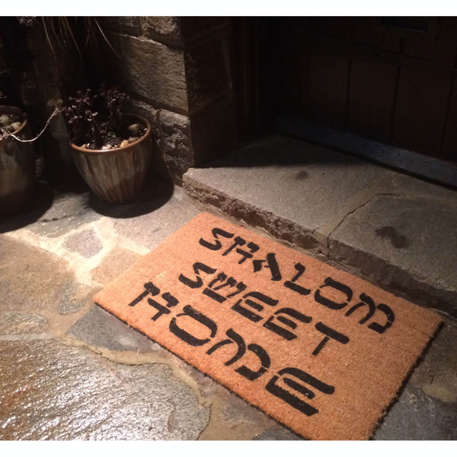 shalom sweet home coir doormat on a slate patio