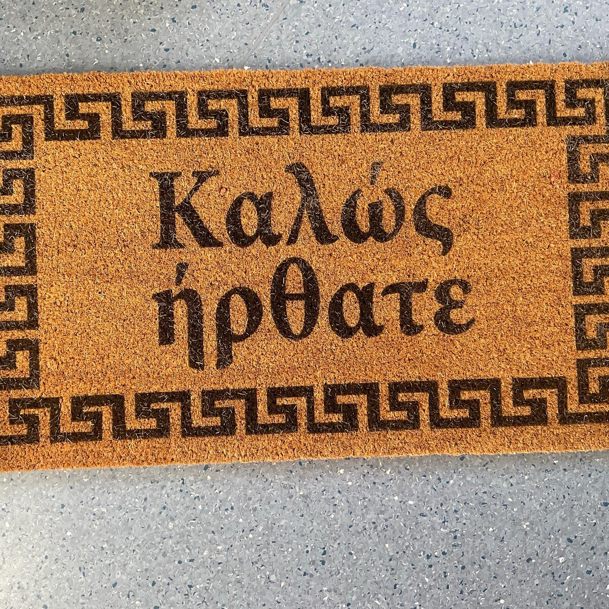 Greek welcome mat reading Kalos Irthate 