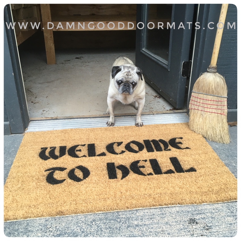 coir Halloween doormat "Welcome to Hell" with a fawn pug looking concerned