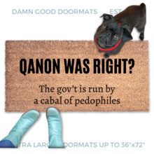 Qanon coir doormat saying "Qanon was right? The government is run by a cabal of pedophiles" . A pair of feet wearing baby blue boots stands with a black pug dog sitting on the floor next to them. 