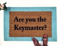 outdoor coir doormat "are you the gatekeeper" on blue layering rug
