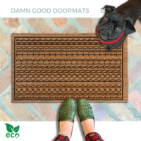 A pair of feet wearing green shoes stands on a subtle patterned FDT Fuck Donald Trump doormat