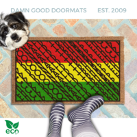 a pair of feet in black and white striped rainboots standing on an all-weather colorful, patterned doormat with a geometric Fuck Donald Trump design in pan-African red, yellow, and green.
