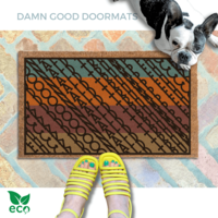 a pair of feet in yellow strappy sandals standing on an all-weather colorful, patterned doormat with a geometric Fuck Donald Trump design and a french bulldog looking up.