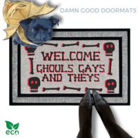 a humorous LGBTQ Halloween door mat with the text "Welcome Ghouls, Gays and Theys". There is also a pug in a gold dragon costume and a person's feet visible in the image.