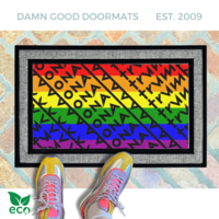 a pair of feet in colorful sneakers standing on a colorful gay pride rainbow flag doormat with a geometric Fuck Donald Trump pattern