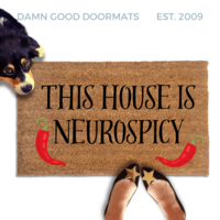 cute dog peeking over a doormat reading "This house is neurospicy" with red chili peppers on it