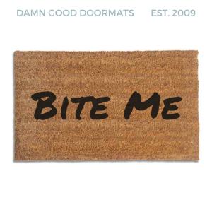 Coir doormat printed with Bite Me in bold black brush lettering