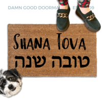 coir doormat reading Shana Tova in english and hebrew with a person in green shoes and a rescue terrier dog