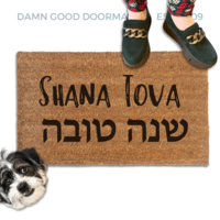 coir doormat reading Shana Tova in english and hebrew with a person in green shoes and a rescue terrier dog