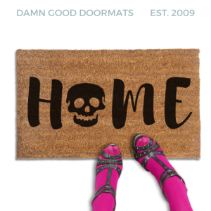 Coir doormat printed with HOME in black brush lettering, with a black skull standing in for the O