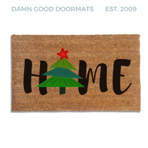 Coir doormat printed with HOME in black brush lettering, with a green Christmas tree topped by a red star standing in for the O