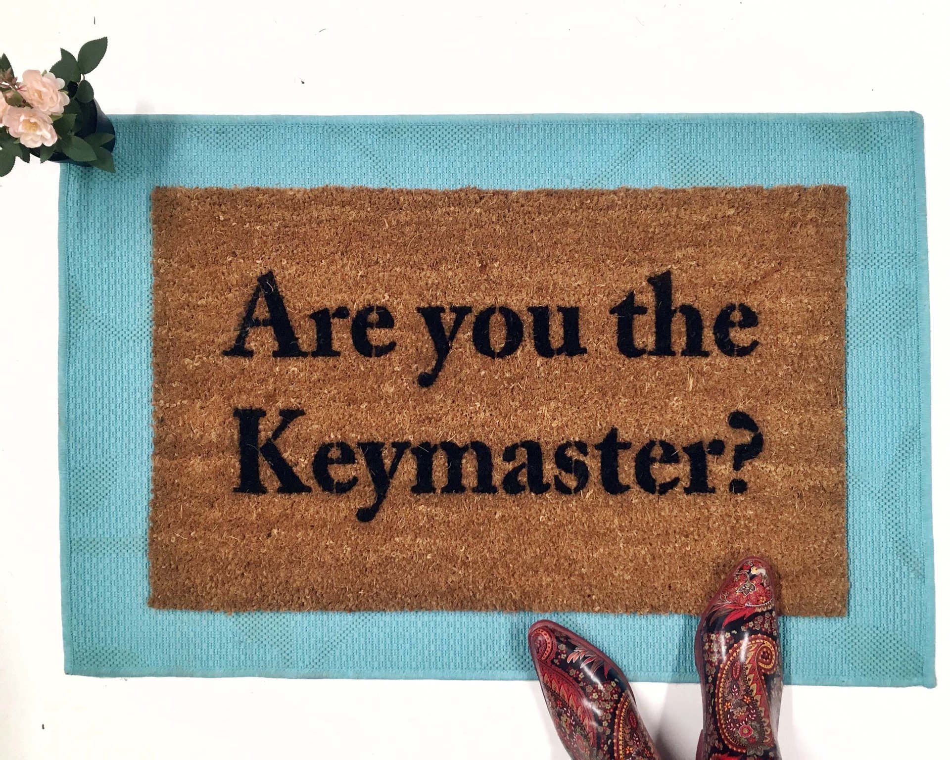 outdoor coir doormat "are you the gatekeeper" on blue layering rug