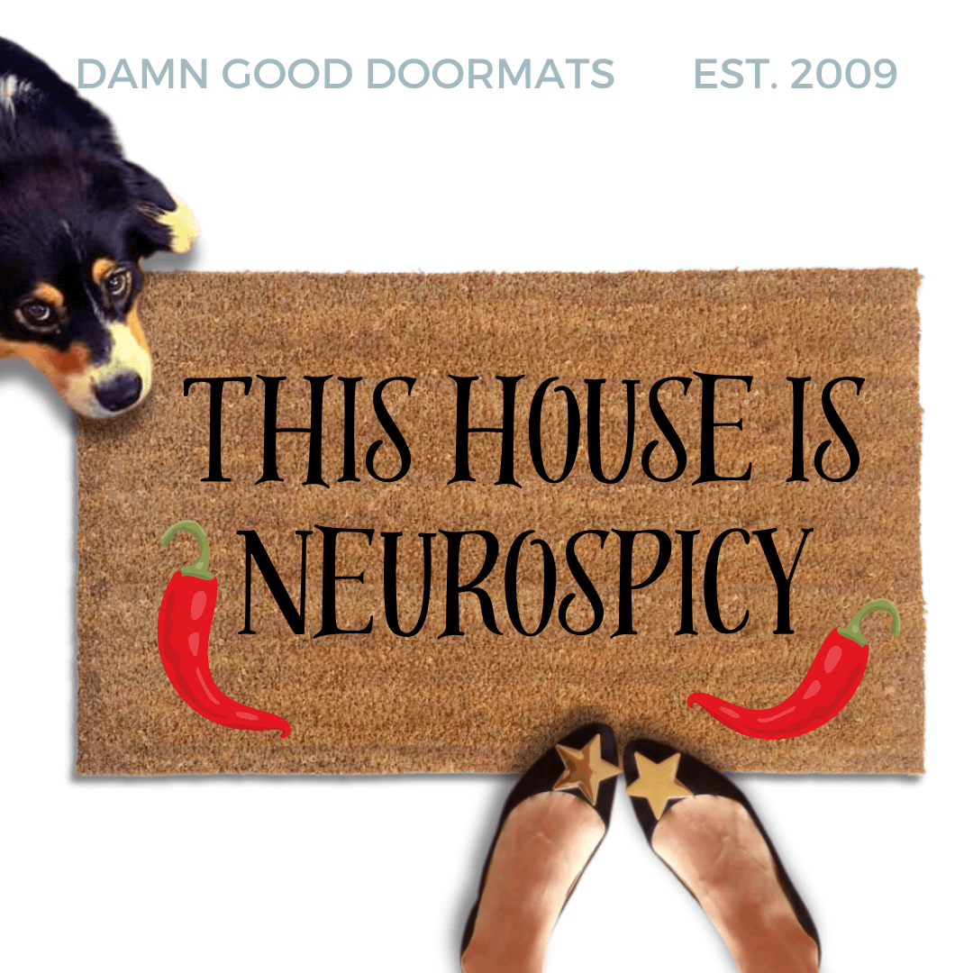 cute dog peeking over a doormat reading "This house is neurospicy" with red chili peppers on it