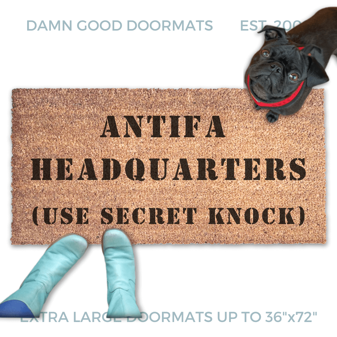 ANTIFA HEADQUARTERS doormat pictured with a little black pug looking up at someone in Smurf blue boots