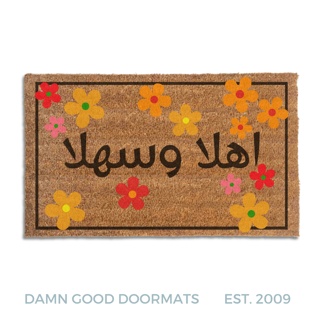 coir doormat with 1960s style hippy Flowers and Welcome in Arabic 