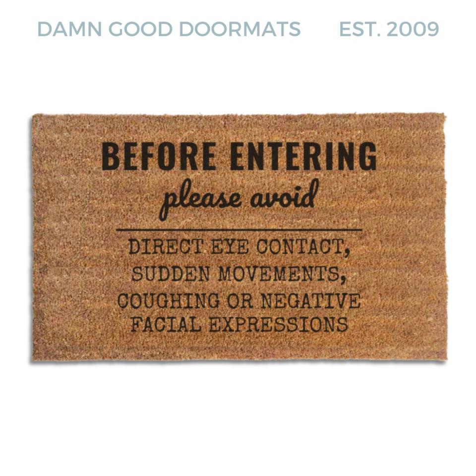 Coir doormat printed with Before Entering Please Avoid Direct Eye Contact, Sudden Movements, Coughing or Negative Facial Expressions in black house-rules lettering