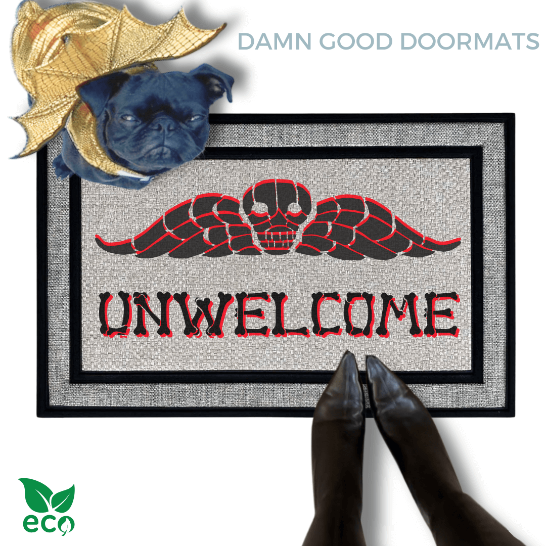 a small black pug in a gold dragon Halloween custom sitting on a welcome mat with the word "UNWELCOME" written on it in bones lettering