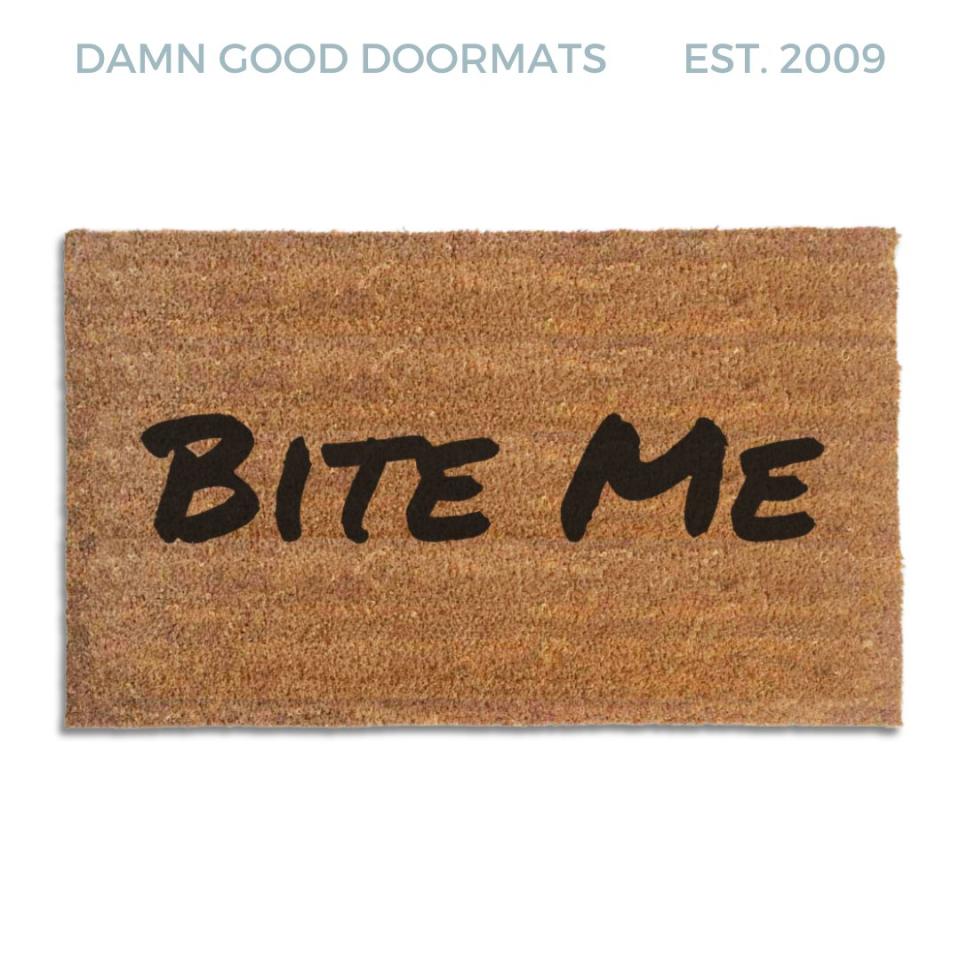 Coir doormat printed with Bite Me in bold black brush lettering