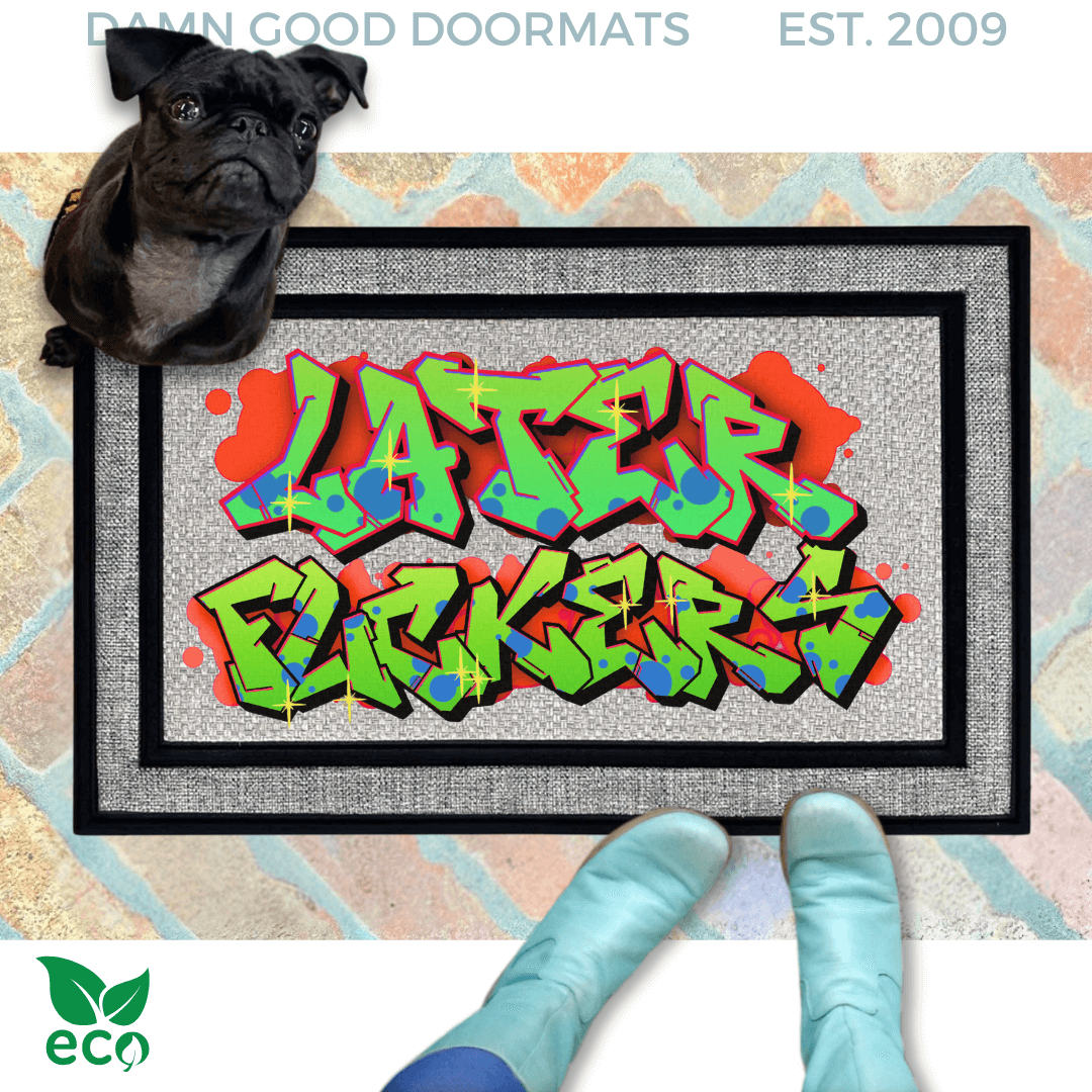 a pair of smurfy blue boots standing on a colorful, graffiti-style doormat with the text "LATER FUCKERS" written on it. A small black pug dog is also present in the scene, sitting on top of the doormat.