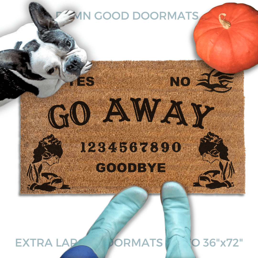a Halloween welcome mat with a french bulldog, the word "GO AWAY" on it. The mat has a Ouija board design and the numbers "1234656789" printed on it. The scene includes a person's feet wearing Smurf blue boots and the text "DAMN GOOD DOORMATS EST. 2009" is visible.
