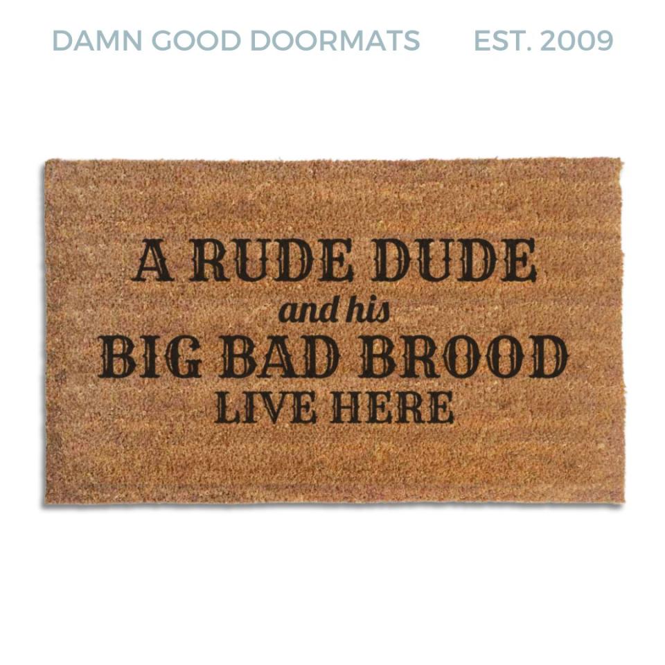 Coir doormat printed with A Rude Dude and His Big Bad Brood Live Here in black western and script lettering