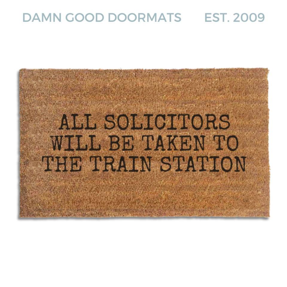 Coir doormat printed with All Solicitors Will Be Taken To The Train Station in black typewriter capitals
