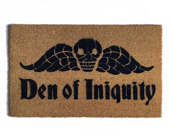 natural coir doormat with gothic skull with wings reading "den of iniquity"