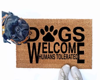 Dogs welcome, Humans tolerated doormat pictured with a silly black pug