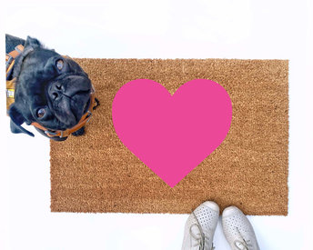 cute pink heart Valentine's Day doormat shown with a little black pug
