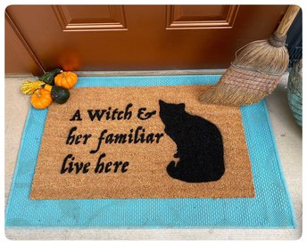 a witch and her familiar live here black cat halloween gothic home doormat