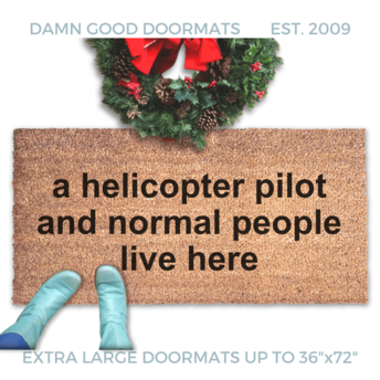 large door mat reading "a helicopter pilot and normal people live here" with a christmas wreath and woman in smurf blue boots