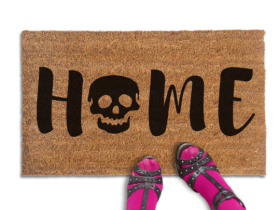 Coir doormat printed with HOME in black brush lettering, with a black skull standing in for the O