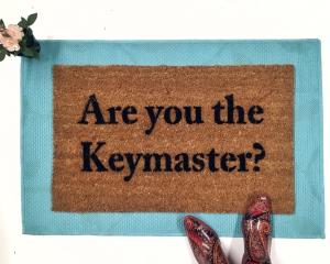 outdoor coir doormat "are you the gatekeeper" on blue layering rug