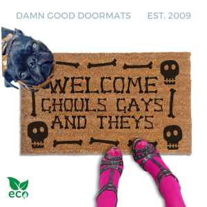 a humorous LGBTQ Halloween door mat with the text "Welcome Ghouls, Gays and Theys". There is also a pug and a person's feet visible in the image.