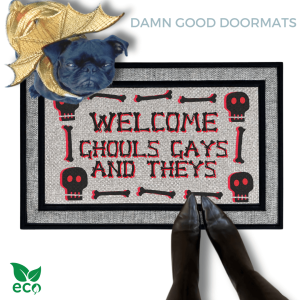 a humorous LGBTQ Halloween door mat with the text "Welcome Ghouls, Gays and Theys". There is also a pug in a gold dragon costume and a person's feet visible in the image.