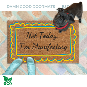 outside coir door mat reading "not today, I'm manifesting" on a red brick patio with a black pug puppy looking up and a woman's feet in smurf blue boots