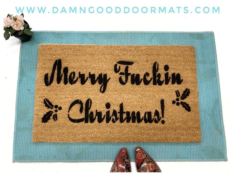 Coir doormat printed with Merry Fuckin Christmas in bold red text, funny holiday welcome mat for a front door.