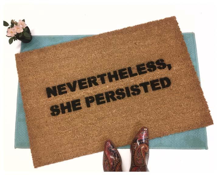 Sustainable coir doormat printed with Nevertheless, She Persisted feminist welcome mat design