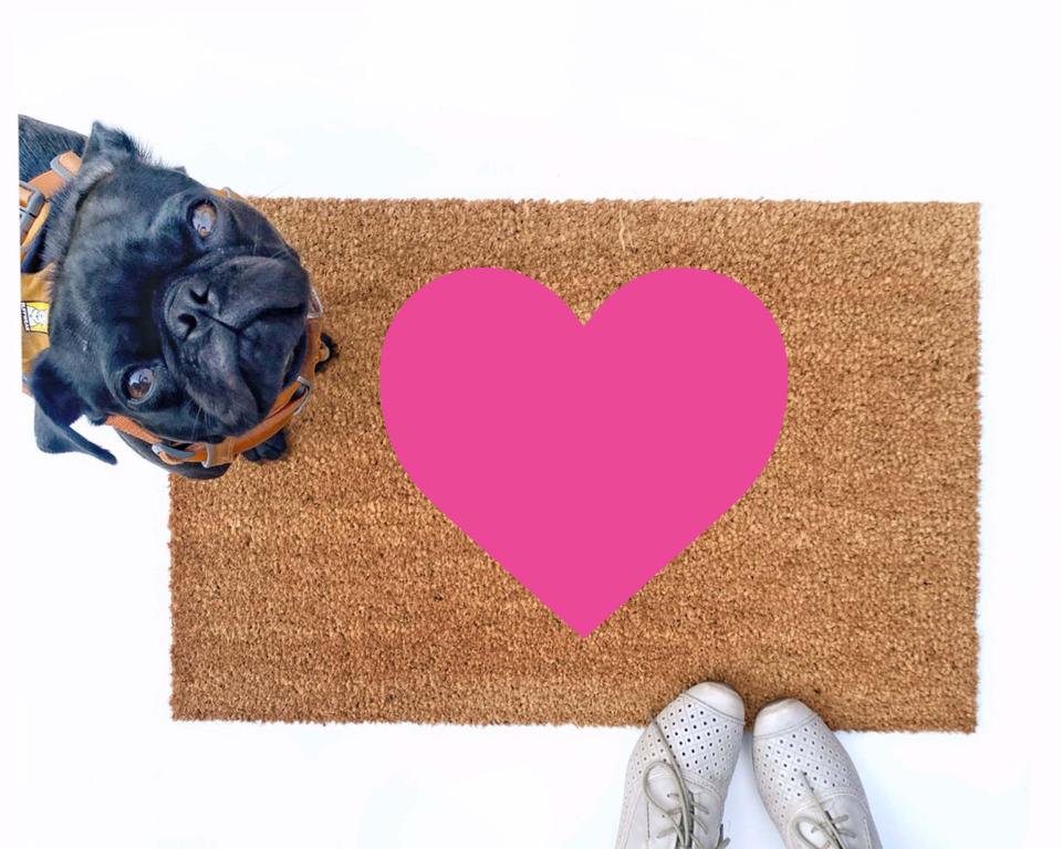cute pink heart Valentine's Day doormat shown with a little black pug