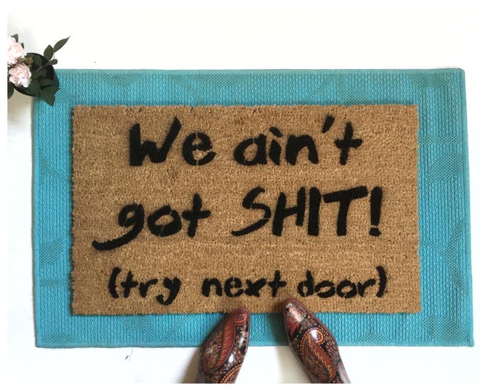 Coir doormat printed with 'We Ain't Got Shit! Try Next Door' funny welcome mat for front porch