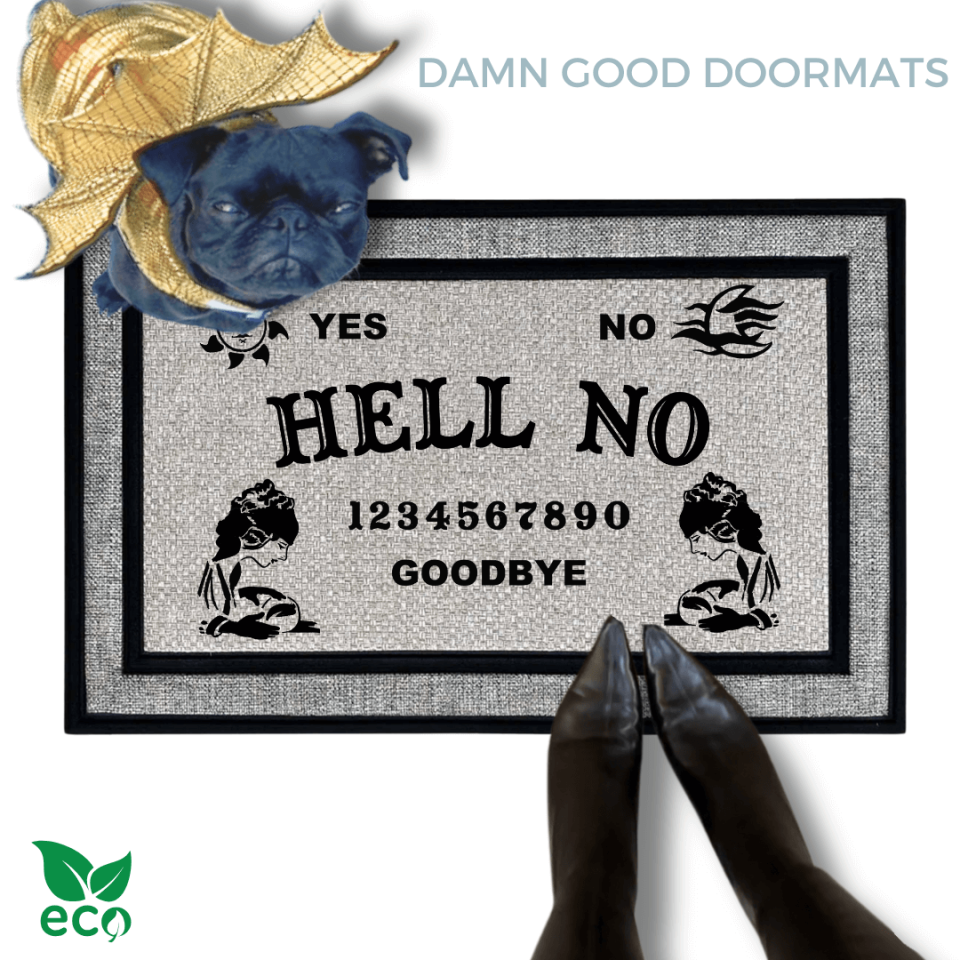 a gray all weather welcome mat with a pug, the word "HELL NO" on it. The mat has a Ouija board design and the numbers "1234656789" printed on it. The scene includes a person's feet wearing black pointy toed witch boots, a vintage Halloween skull and cat light, and the text "DAMN GOOD DOORMATS EST. 2009" is visible.