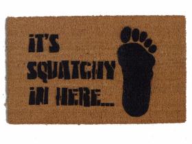 Natural coir Bigfoot Sasquatch doormat with a brown cryptid silhouette striding across the welcome mat