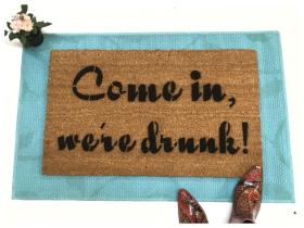 coir doormat with the text "Come, We're Drunk" in bold white lettering, funny house party welcome mat by Damn Good Doormats.