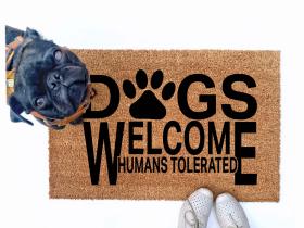 Dogs welcome, Humans tolerated doormat pictured with a silly black pug