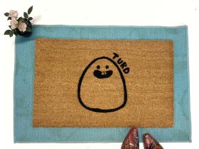 Tan coir doormat printed with a cartoon turd — funny front door mat from Damn Good Doormats